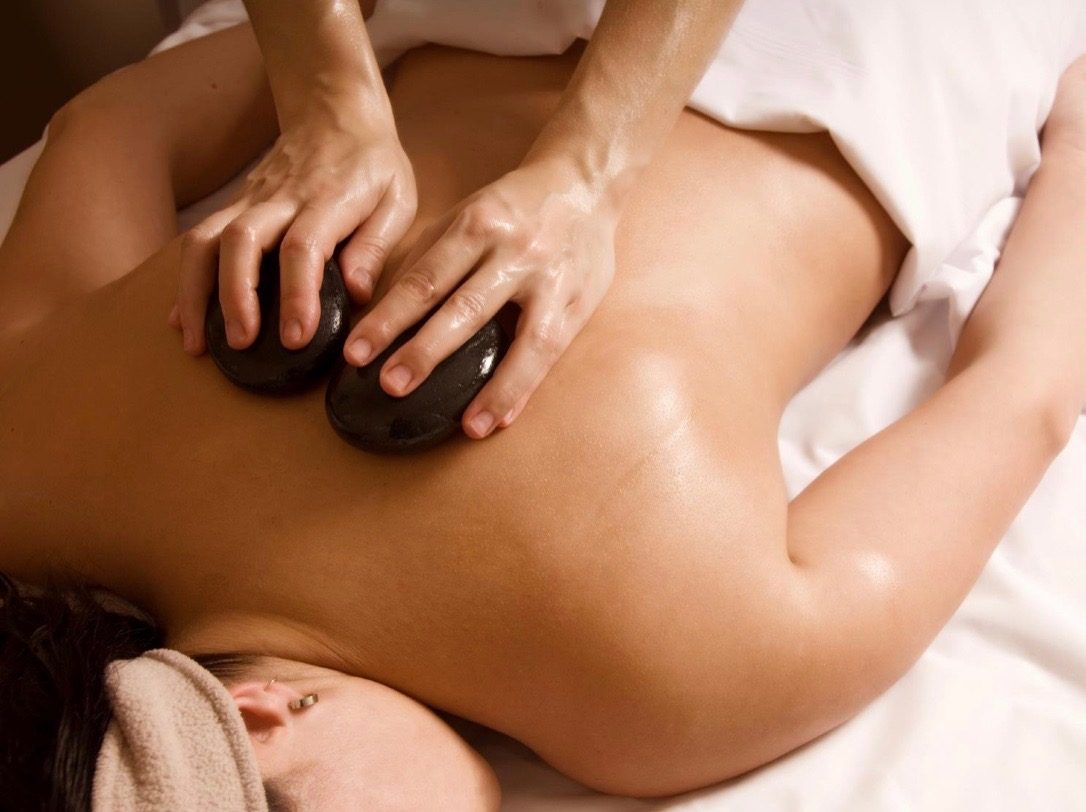 Hot stone massage on a client's upper back