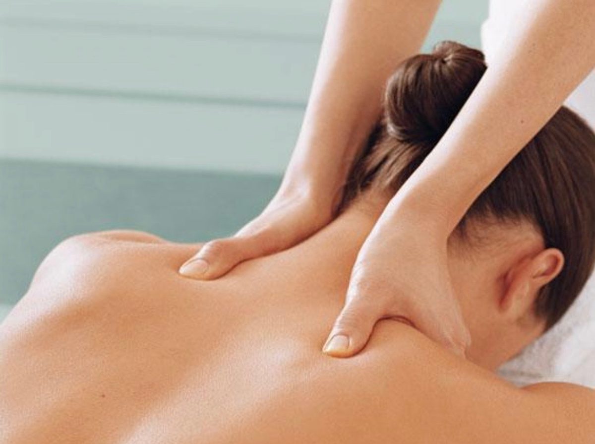 Massage therapist working on a client's neck and shoulders